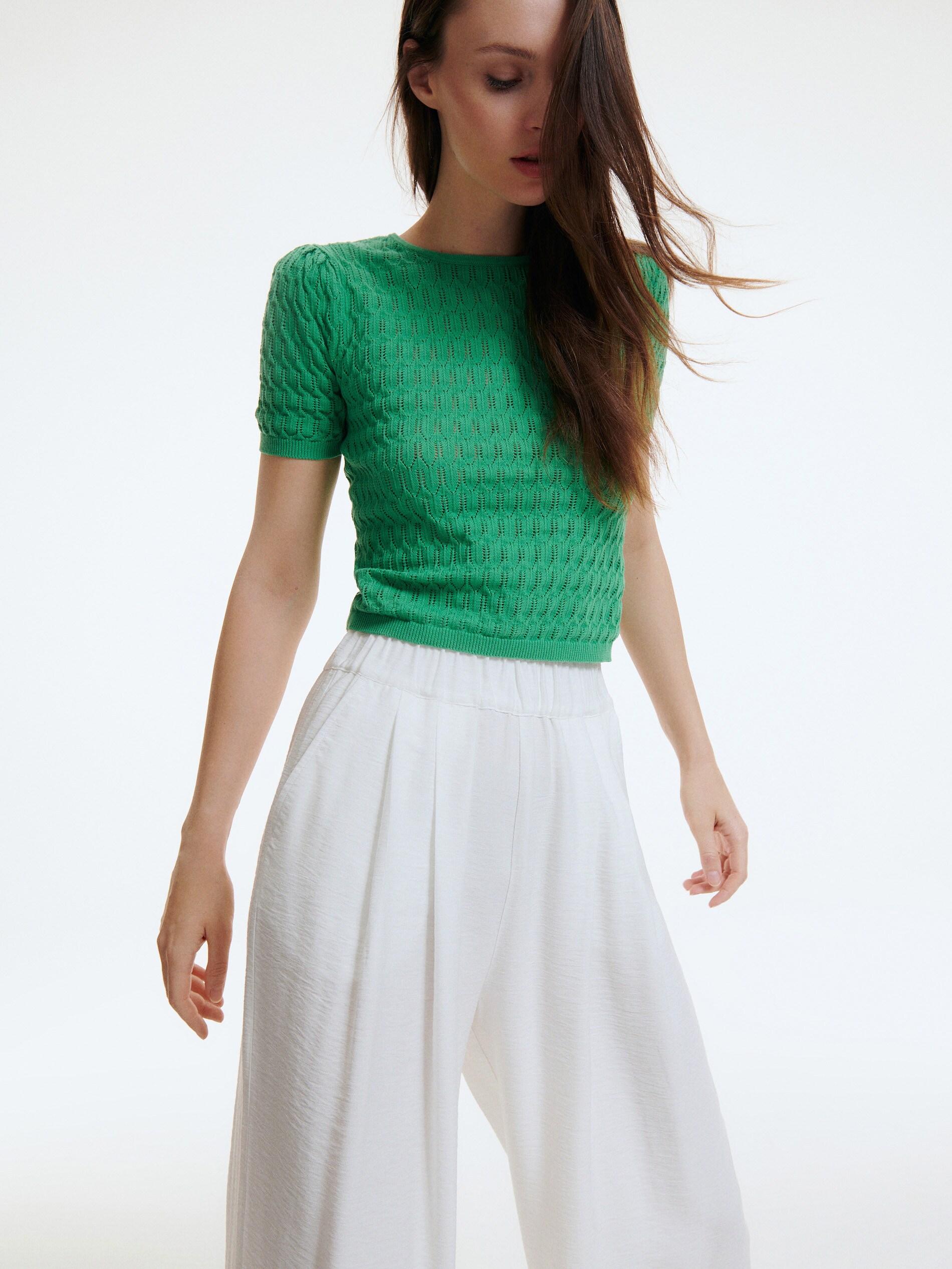 Short sleeved green openwork knit top with round neck and ribbed cuffs and hemline. Cropped close fit. 