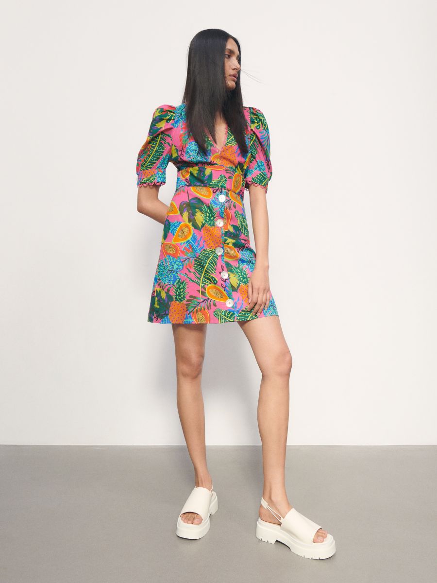 V neck button down mini dress form Reserved with a bright tropical floral print and puff sleeves. Cinched in under the bust with an a-line silhouette. Large pearly effect buttons. Scalloped edged on the cuffs at the elbow length sleeves. 